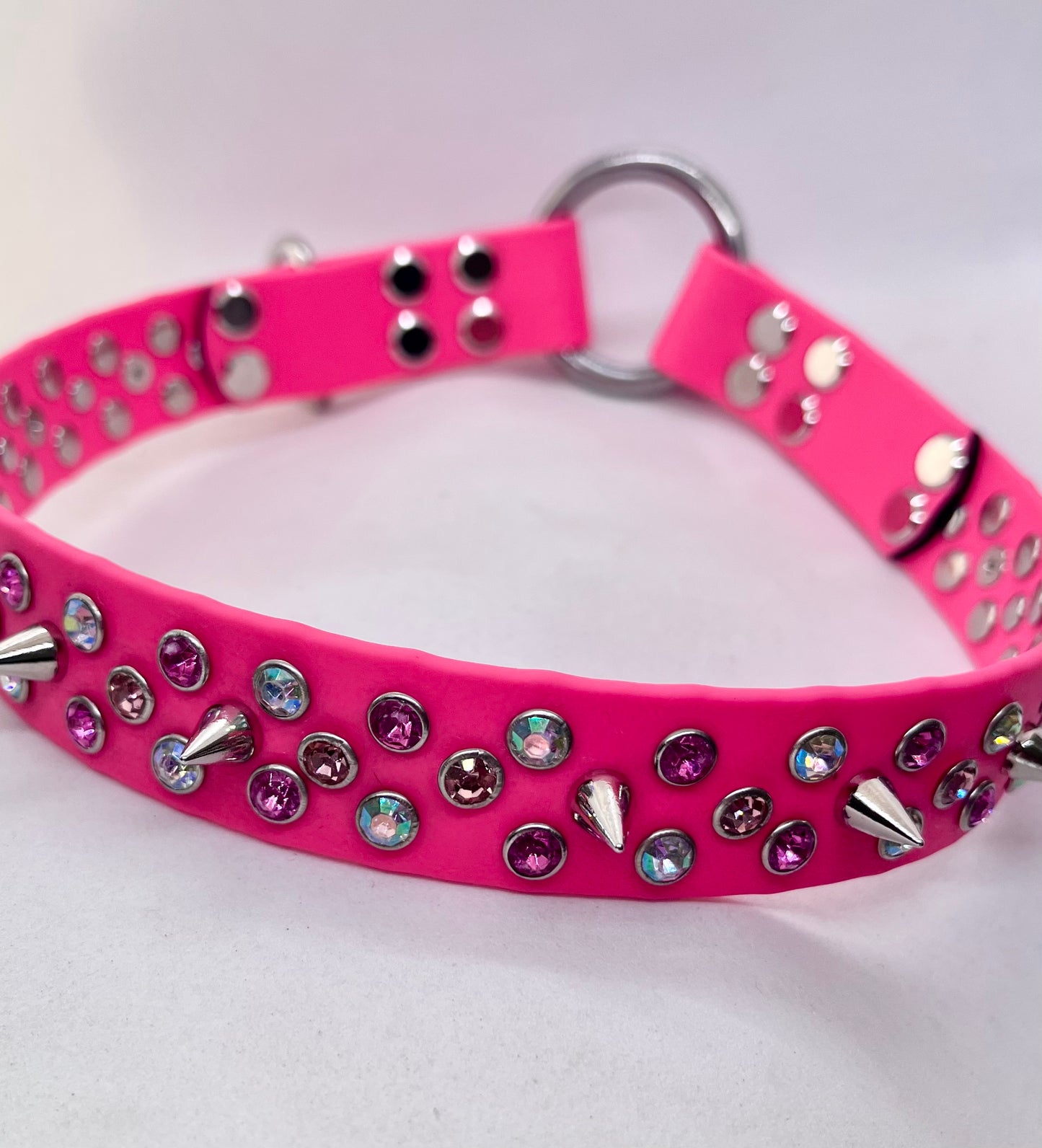Top-down view of neon pink BioThane dog collar showing full rhinestone crystal and spike stud pattern