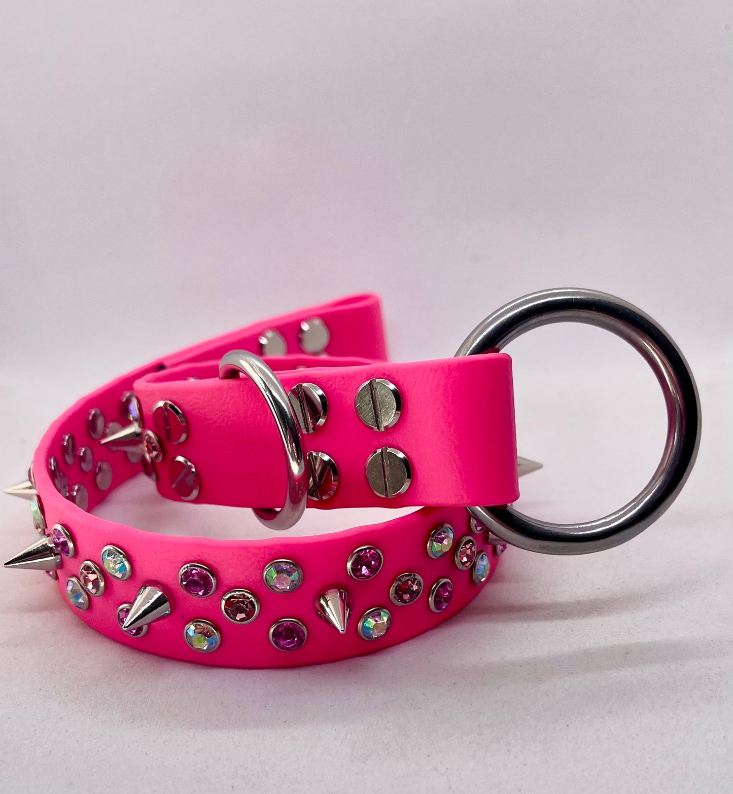 Side angle of neon pink rhinestone spiked BioThane dog collar with stainless steel O ring