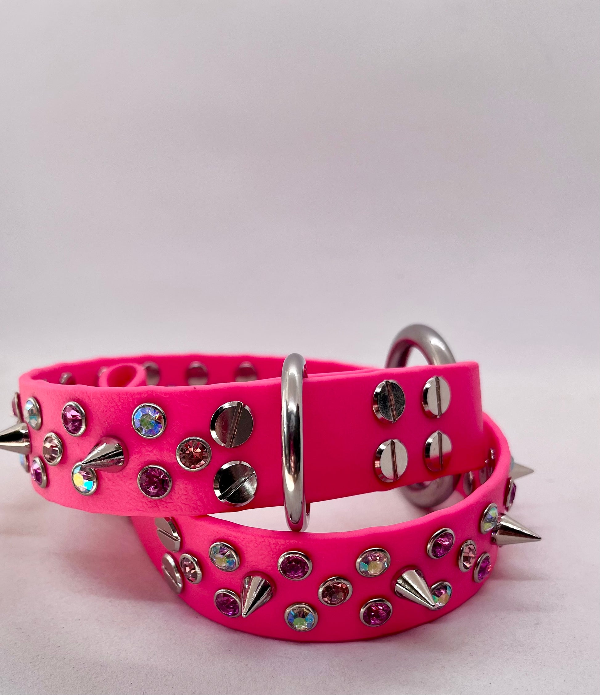 Neon pink rhinestone crystal BioThane dog collar laid flat showing full sparkle and spike detail