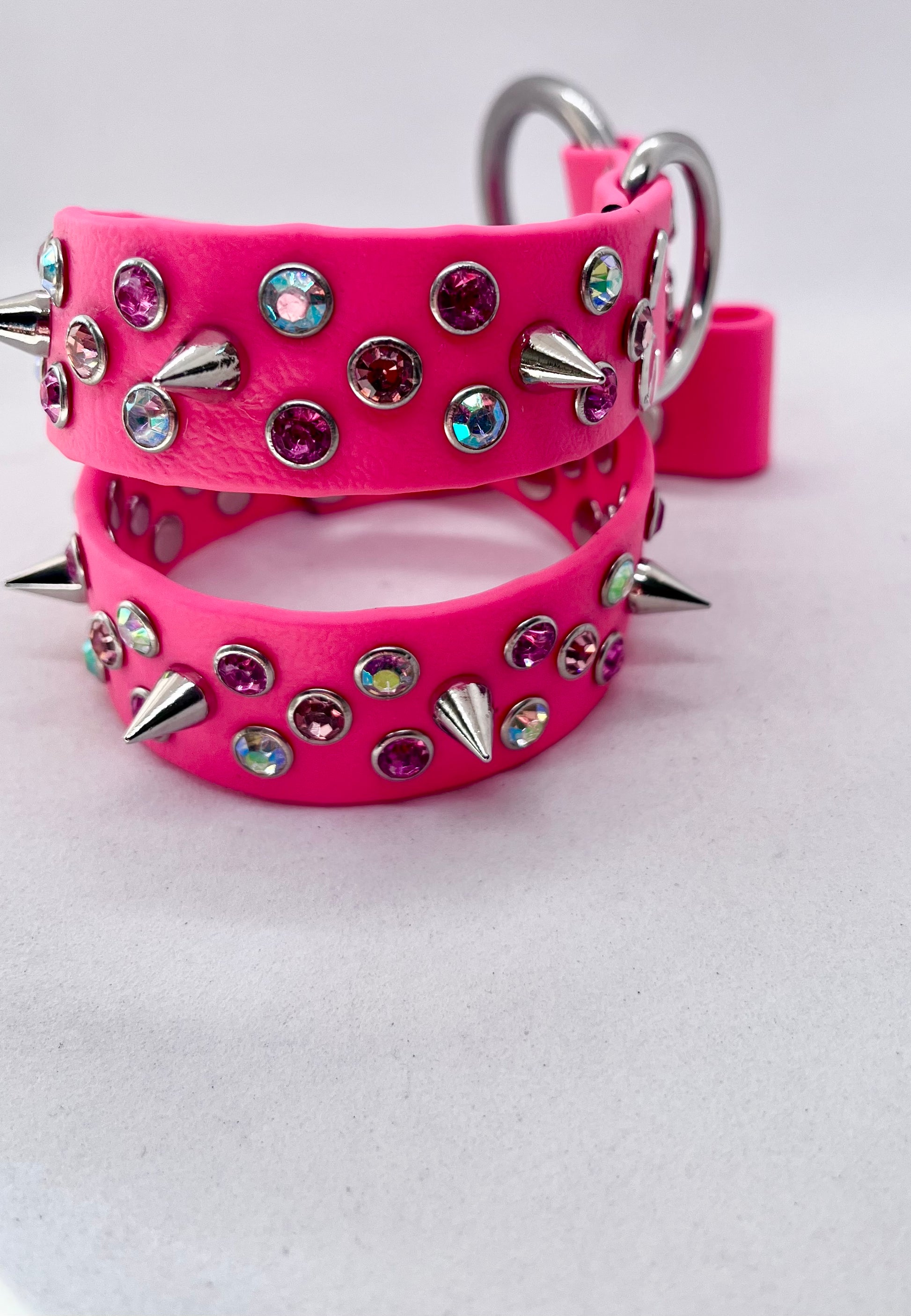 Close-up of neon pink BioThane collar showing stainless steel O ring and mixed rhinestone crystal studs