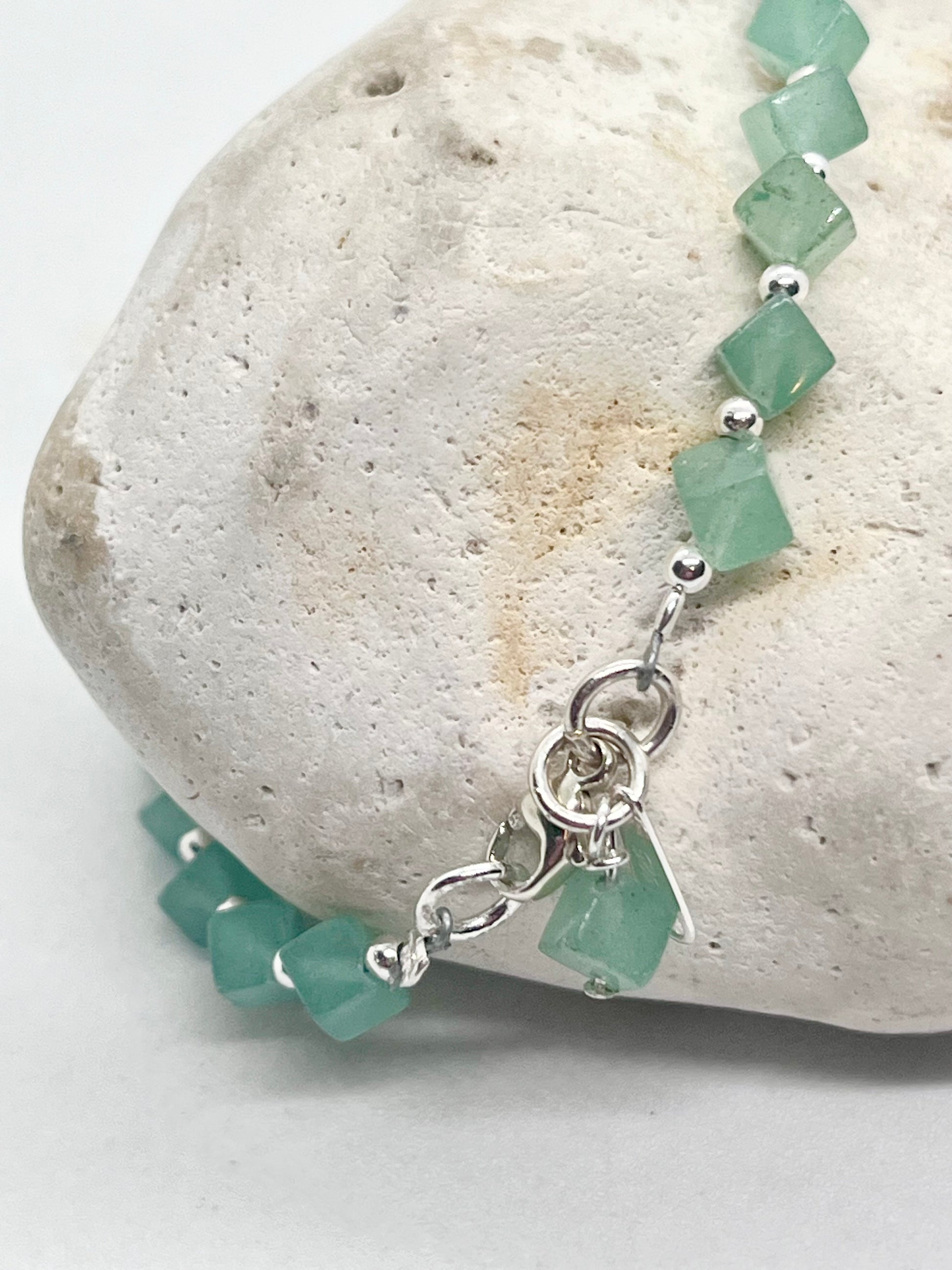 Green beaded bracelet with silver clasp and charms